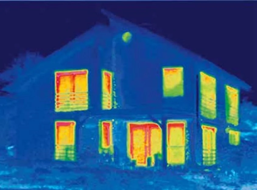 Warmtebeeld van een woning: rood en geel rond de ramen laat zien waar warmte weglekt via de kozijnen