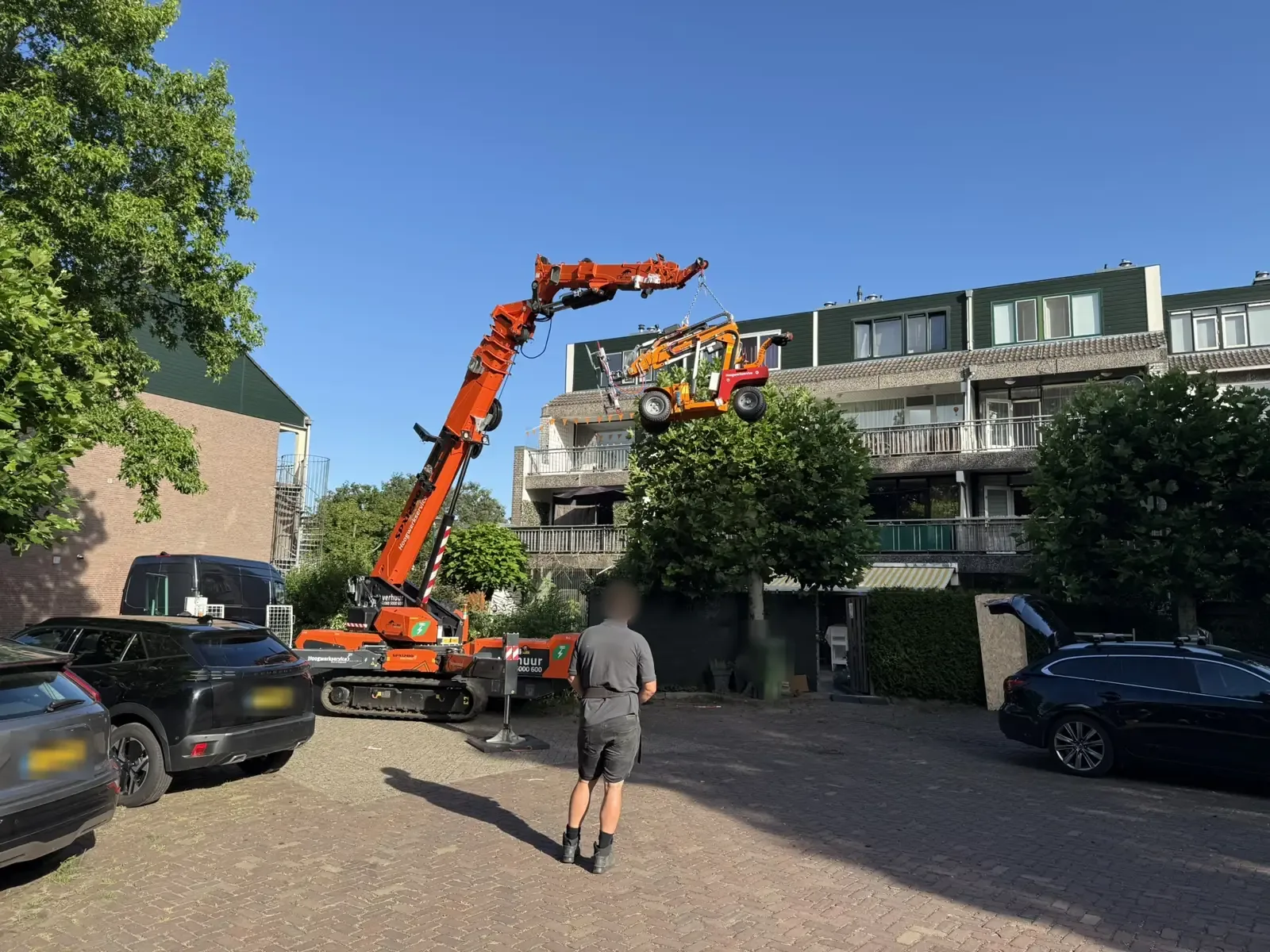 Nieuwe kozijnen worden met een kraan bij een appartementengebouw geplaatst