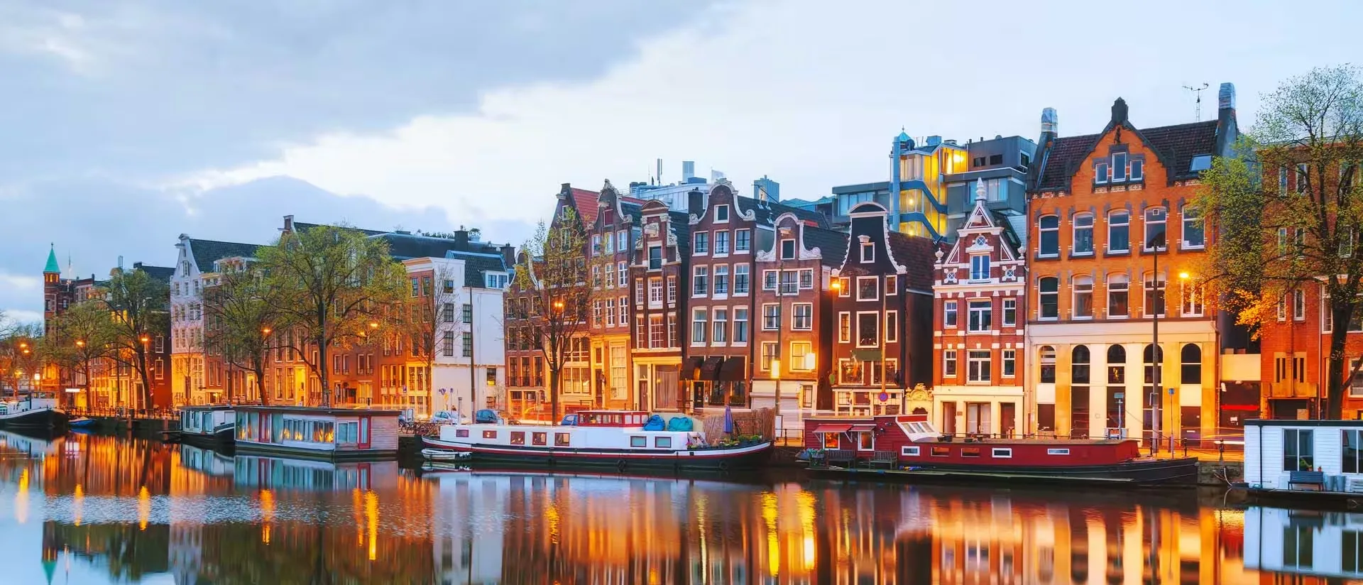 Amsterdamse grachtenpanden bij avondlicht